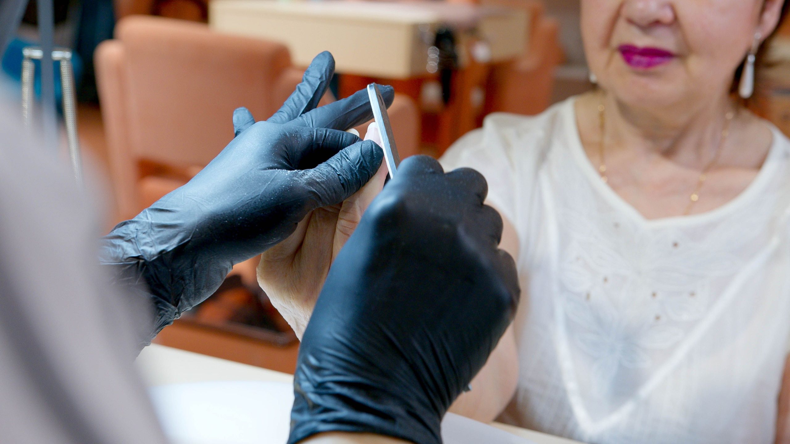 Senior receiving gentle professional nail care