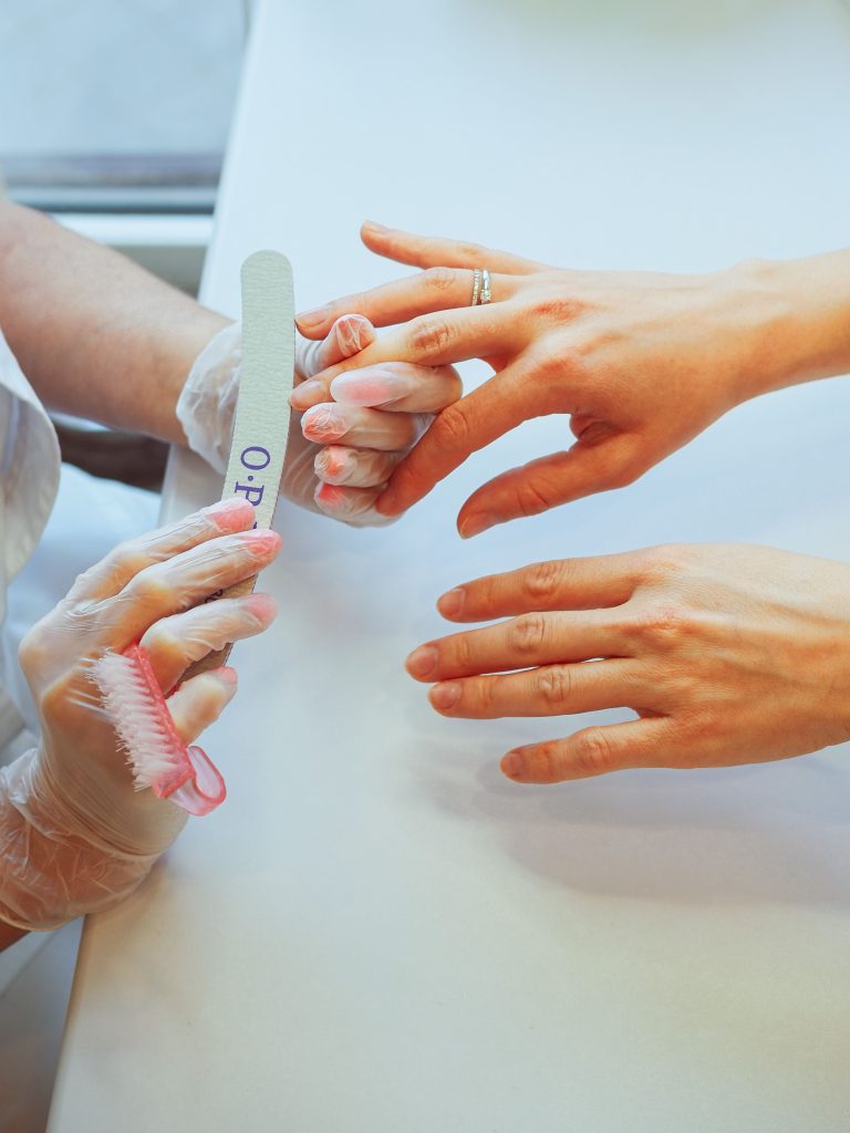 Close-up of a professional manicure session in a spa, focusing on nail care and hygiene.